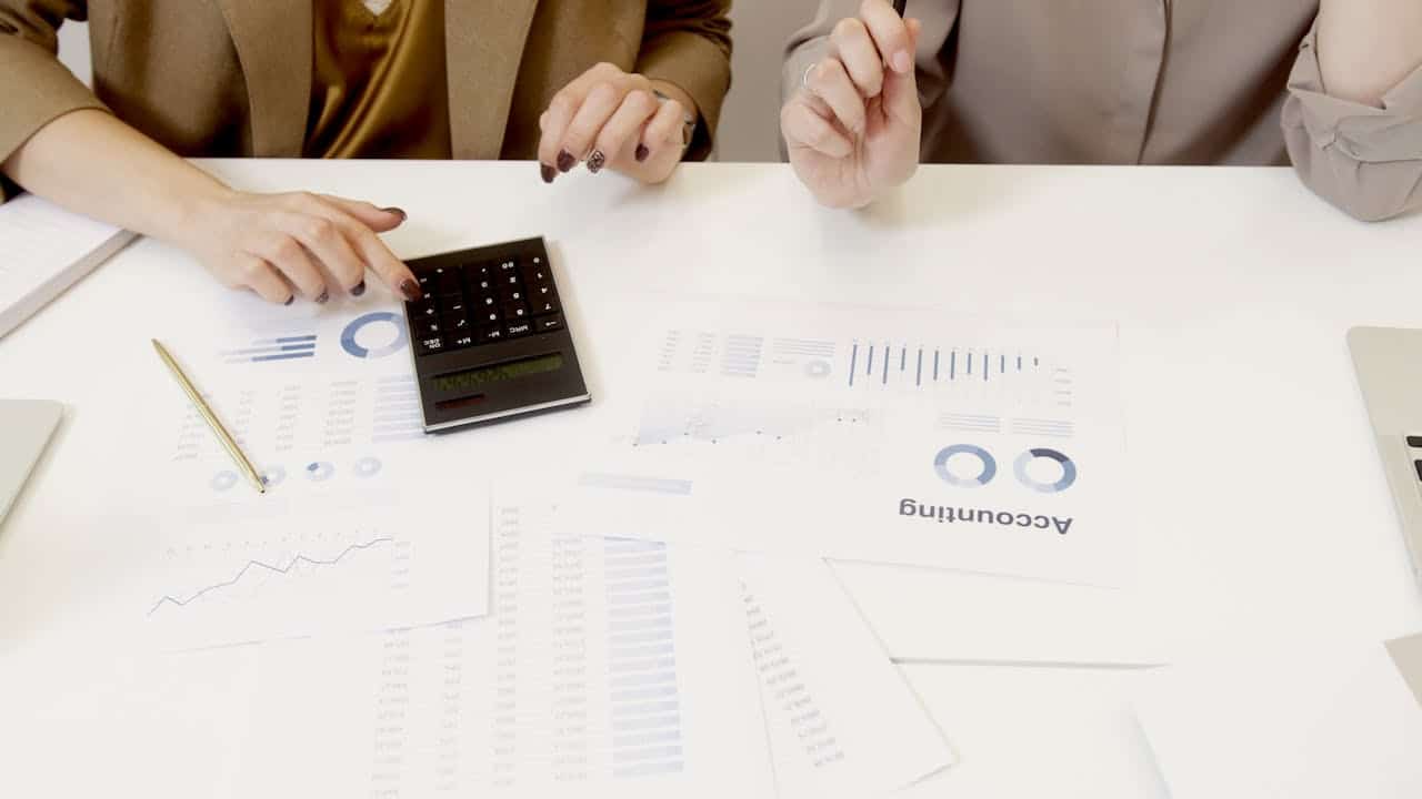 Services Two professionals analyzing financial documents with a calculator.