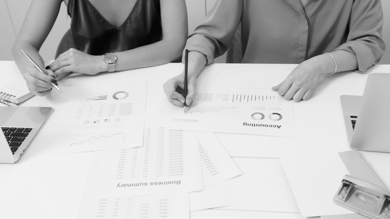 Services Two professionals analyzing financial documents in a modern office setting.
