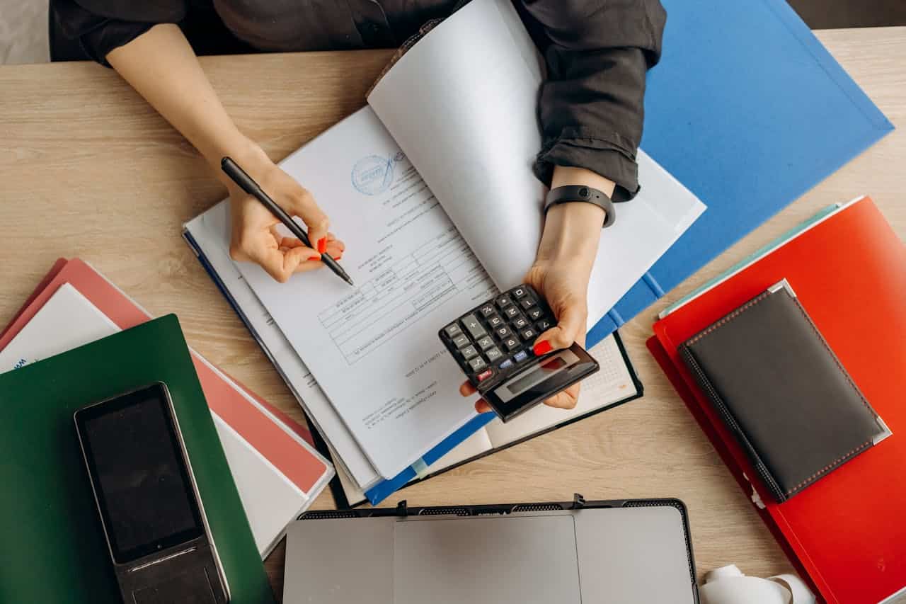 About Accountant analyzing financial documents with a calculator on a desk, highlighting business tasks.