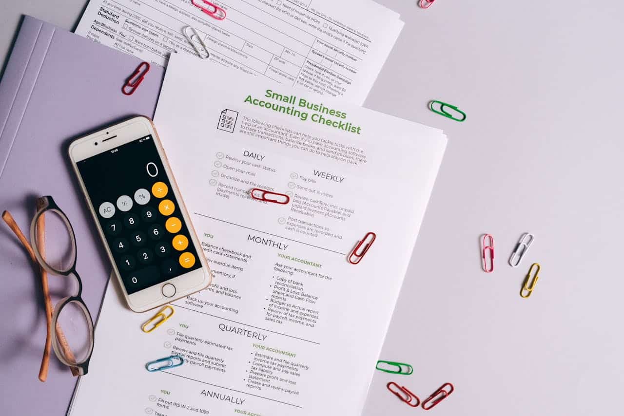 Services Top view of accounting essentials including smartphone, eyeglasses, and paperwork.